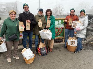 In Foto 6 Grüne Mitglieder mit Brezntüten zum Verteilen in der Hand
